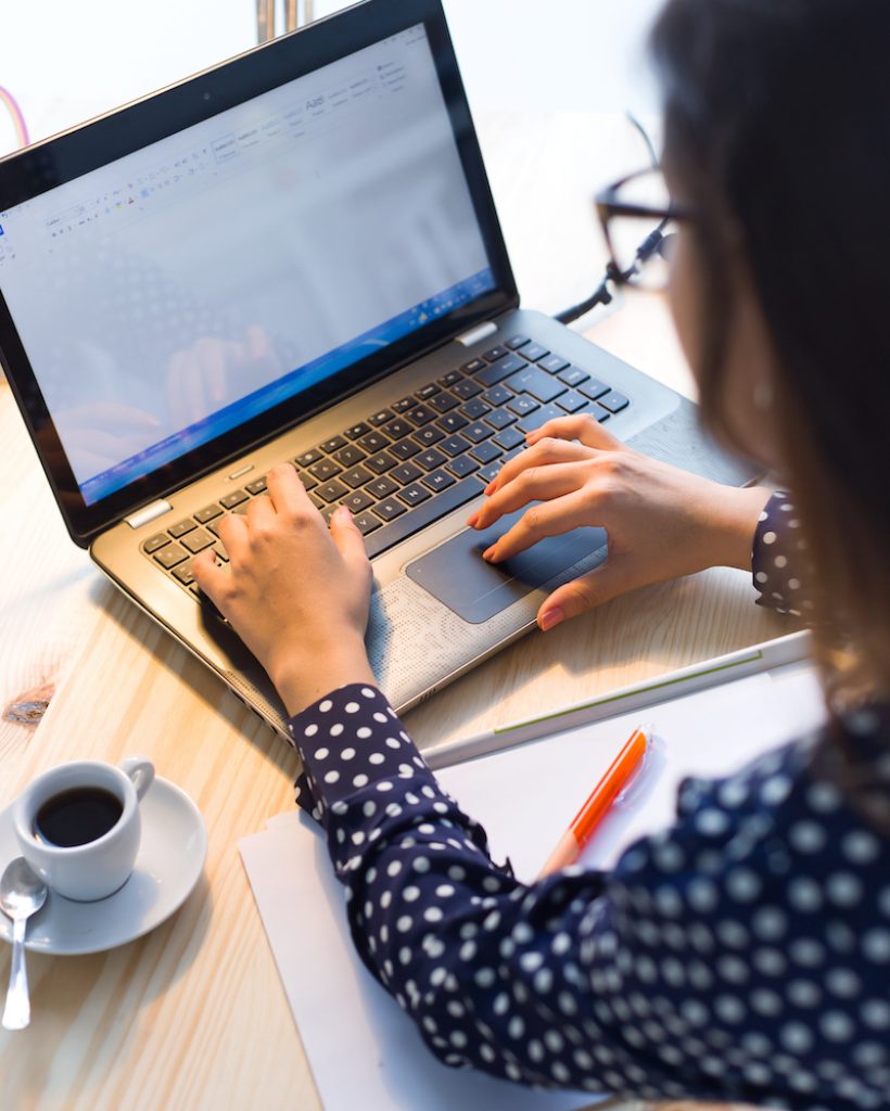 Portrait of beautiful young woman working with laptop in her office.